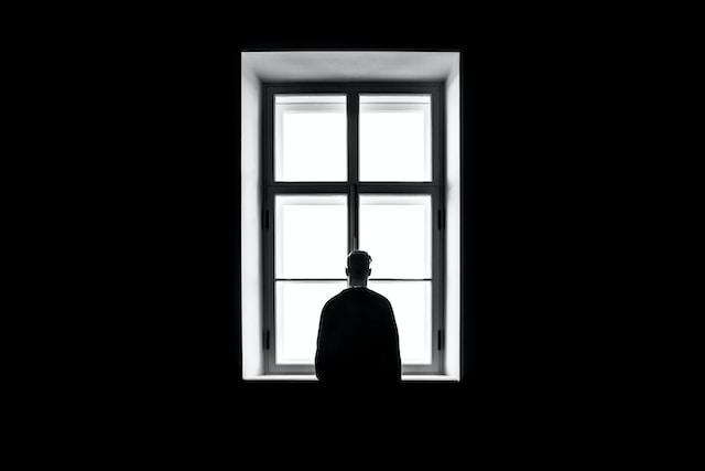 Man looking out window thinking about clinical depression therapies