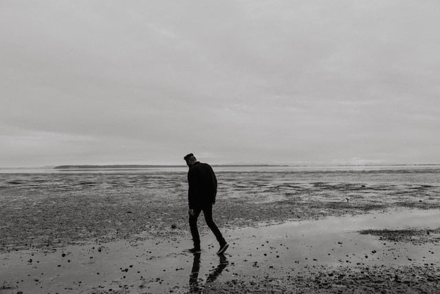 Man on beach explore the hidden loneliness in relationships.