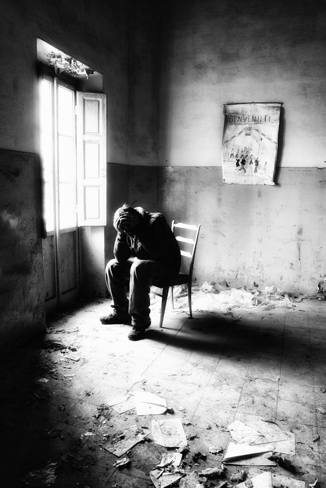 Man sitting on a chair by himself suffering from anxious attachment