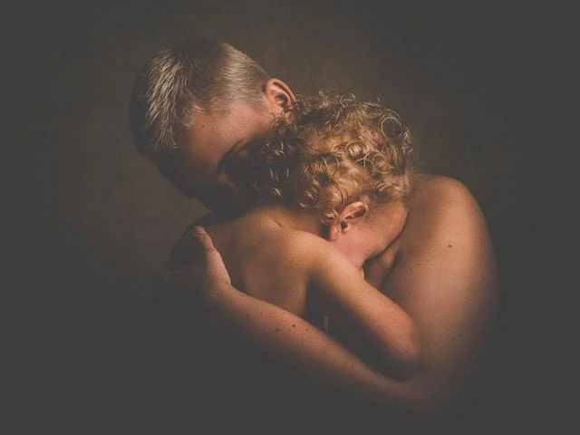 A little boy with his Mom crying over his Mother Wounds