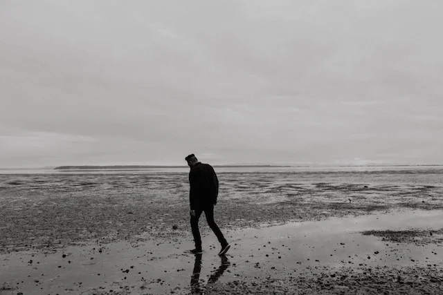 Man on beach explore the hidden loneliness in relationships.