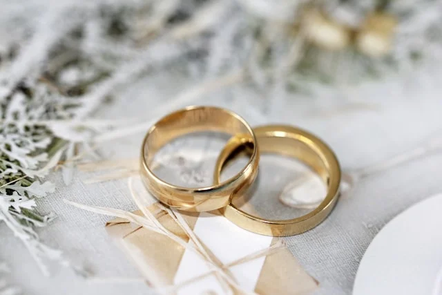 Two gold wedding rings on a delicate background, symbolizing marriage and the complexities of relationships.
